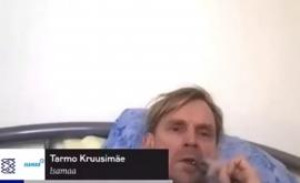 Un parlamentar din Estonia relaxat în pat fumează și ascultă muzică în timp ce intervine la o dezbatere din Parlament