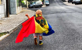 Imaginea zilei Un copilaș cu drapelul R Moldova în spate fotografiat în Portugalia