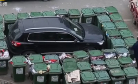 Китайский дворник заблокировал мешавший ему автомобиль мусорными баками