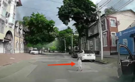 Momentul în care o fetiță aleargă în fața unei mașini