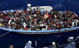 Momentul în care o barcă cu zeci de migranți ajunge pe o plajă de lux plină cu turiști