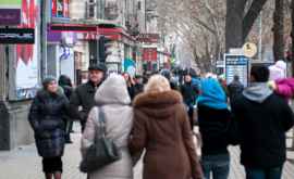 Mai mulţi oameni se plimbă prin oraş în plină pandemie