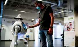 Un robot angajat al unui spital Măsoară temperatura și verifică dacă ai mască