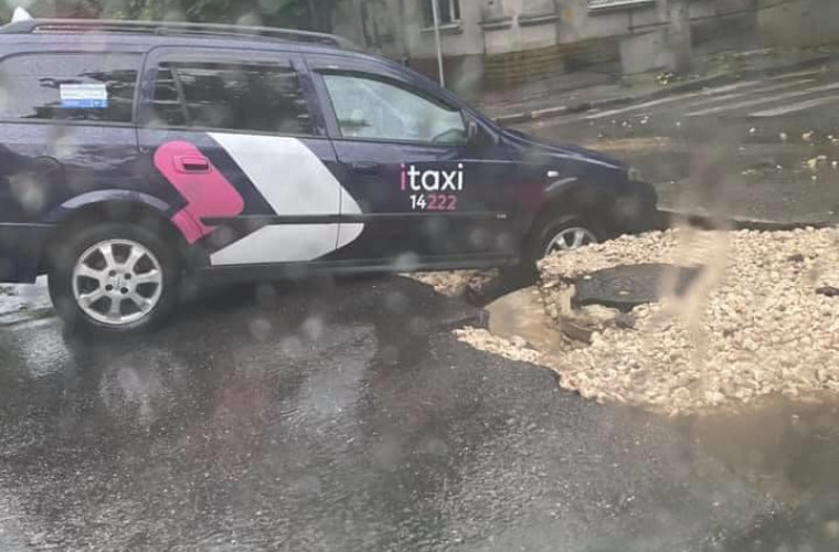 Un taxi a ajuns azi-dimineață într-o groapă din mijlocul drumului în capitală (FOTO)